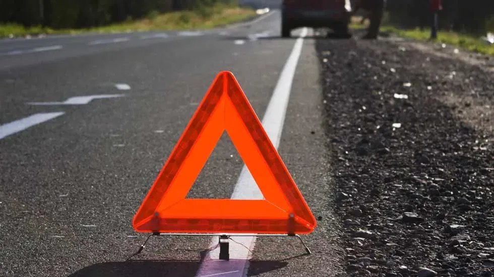 Triangulo  de seguridad colocado a una distancia segura de un vehículo averiado