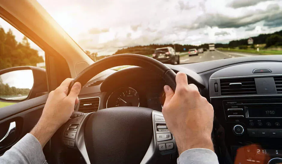 Manos al volante de auto en carretera