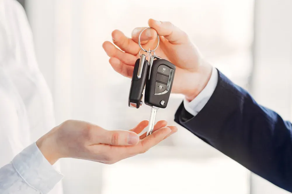 Mano sosteniendo  llaves de auto sobre otra mano