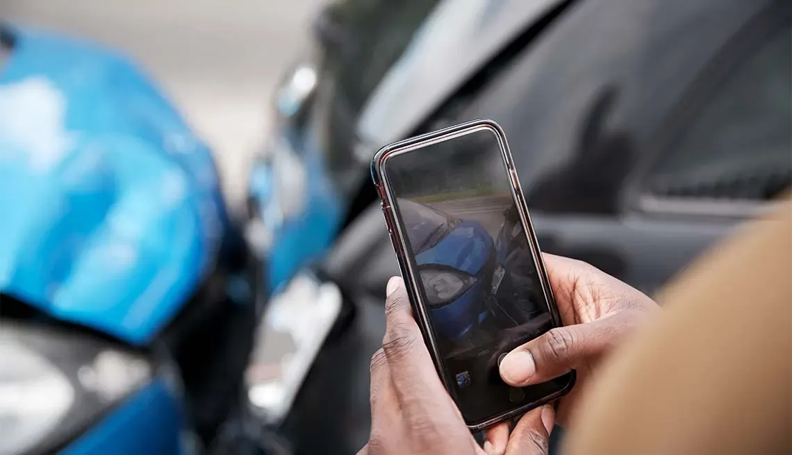 Persona tomando fotografía como evidencia del choque entre dos autos