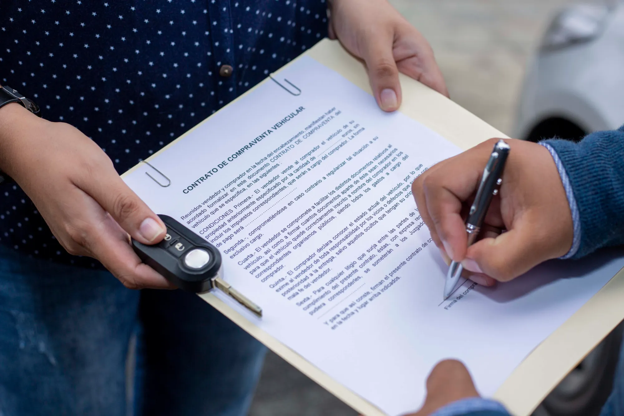 Persona firmando contrato de compra venta de auto