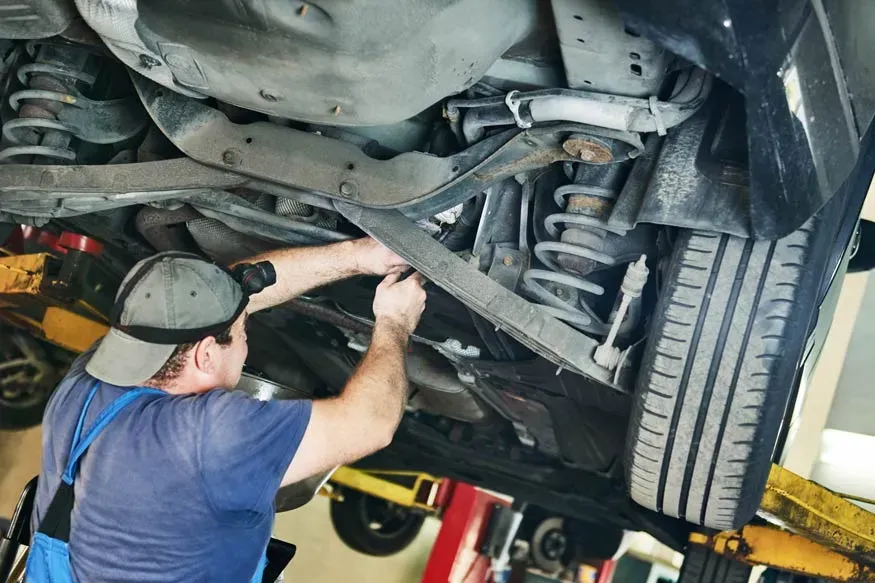 Persona revisando suspensión de auto 