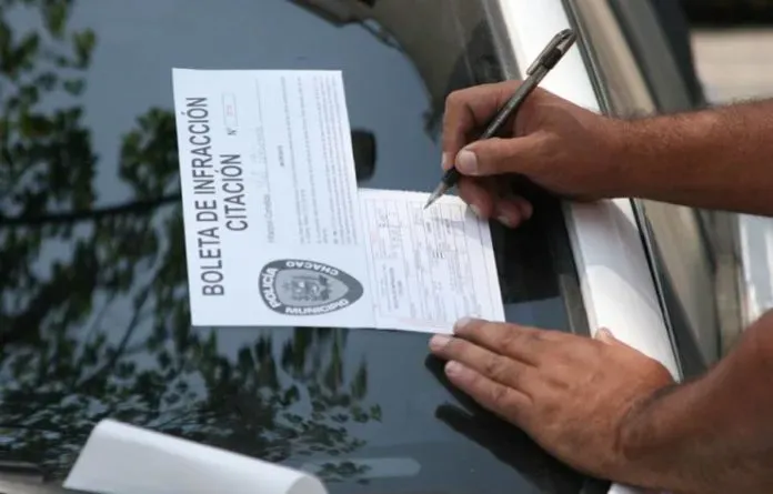 Redactando multa de transito en espejo palabristas de auto