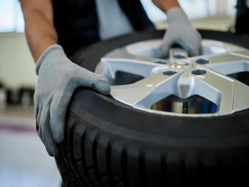 Manos con guantes sobre rueda de auto