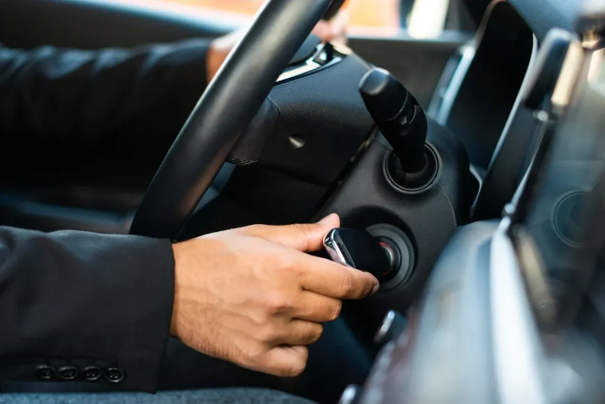 Persona girando llave de auto para encenderlo