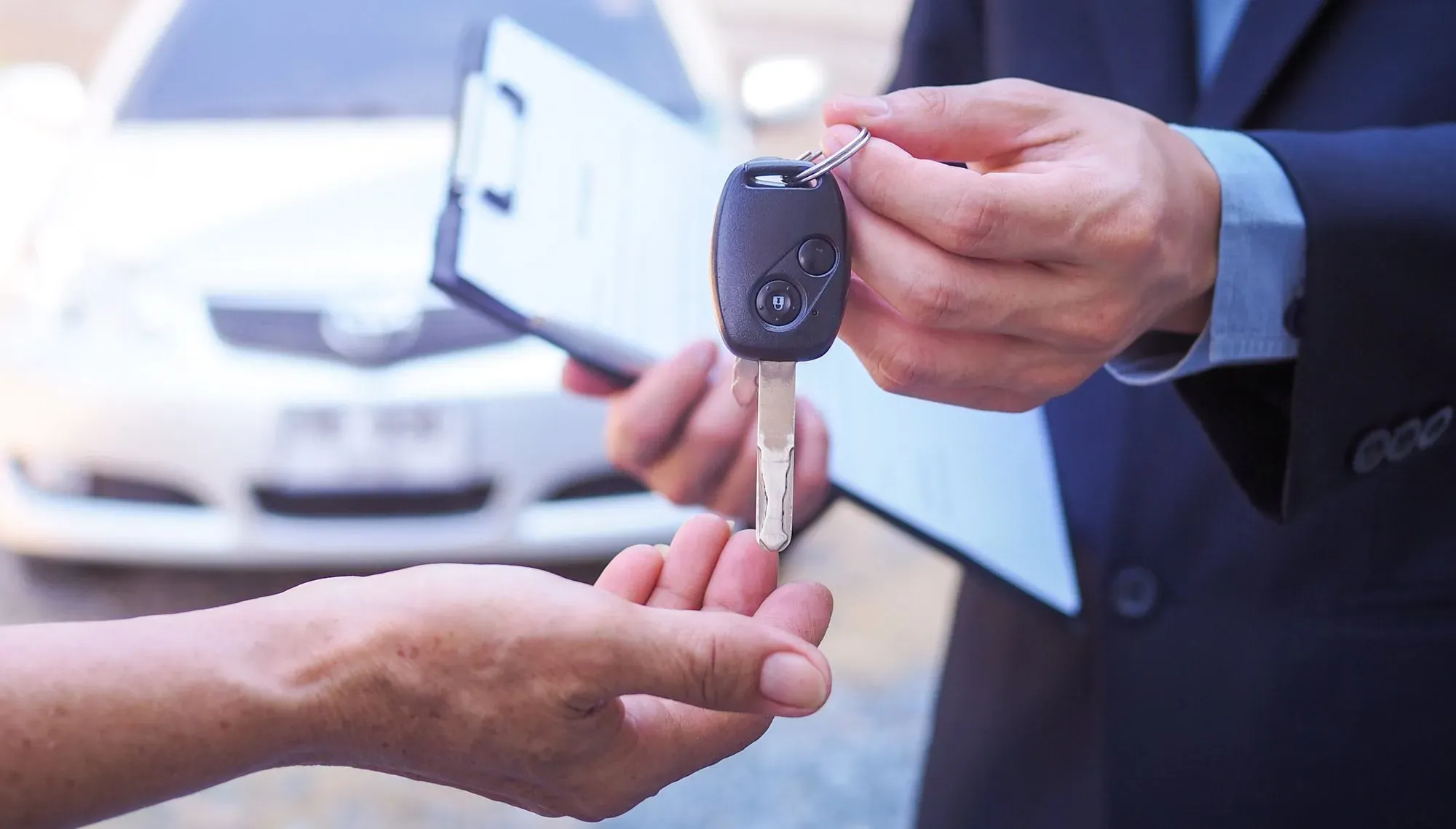 Persona entregando llaves de auto a otra persona