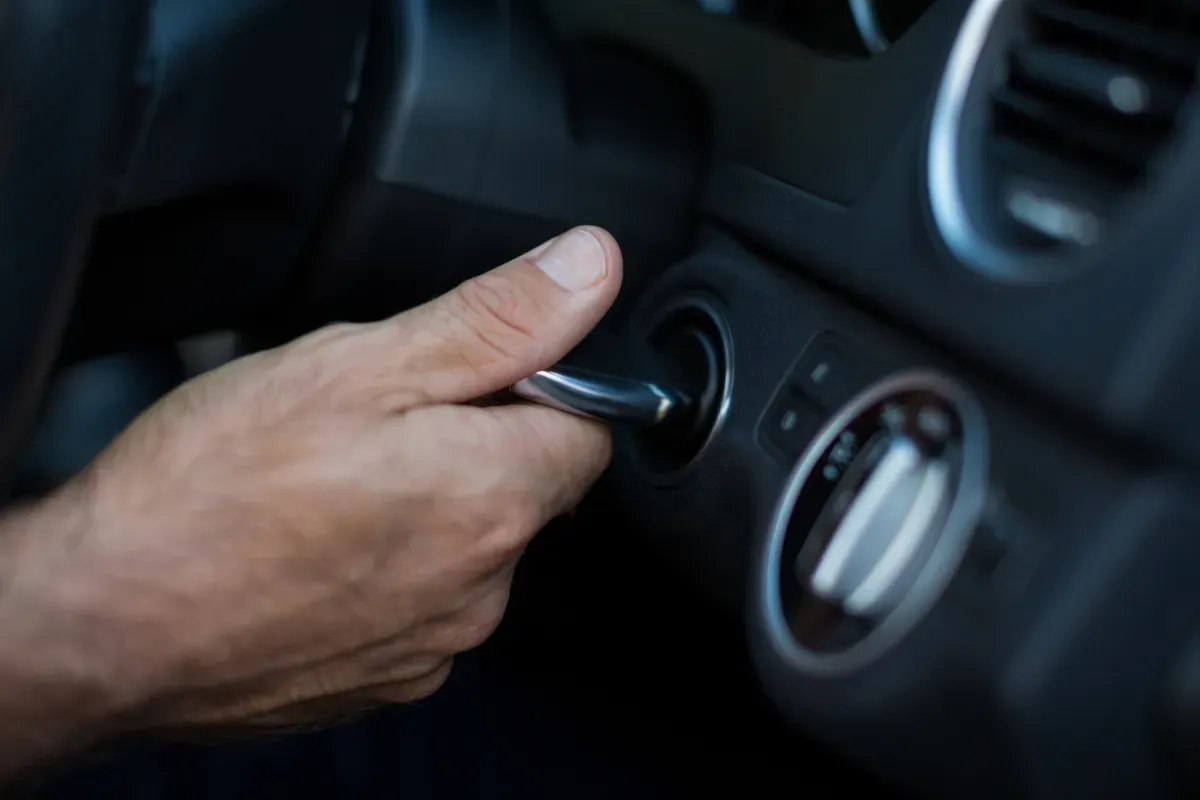 Persona girando llave de auto dentro de bombín de auto