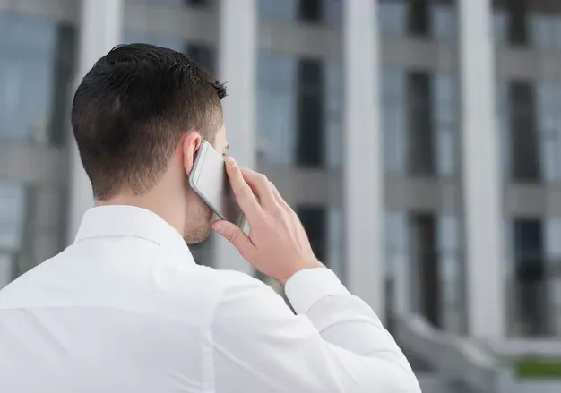 Persona de espaldas realizando llamada telefónica 