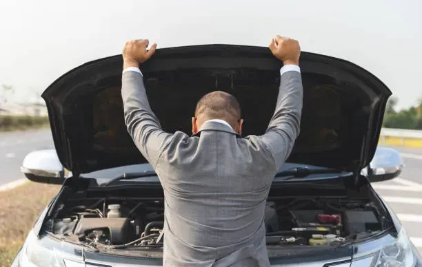 Persona de espaldas abriendo capo de auto