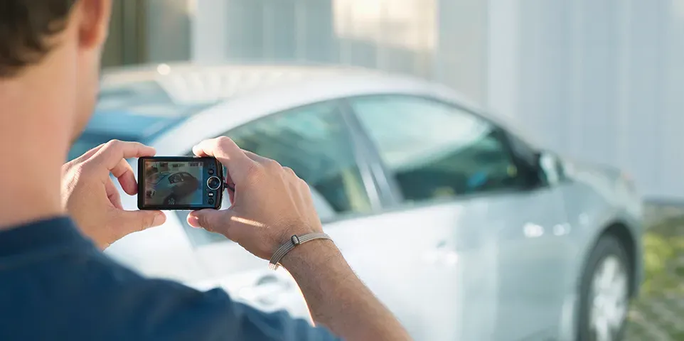 Persona tomando fotografía a un auto