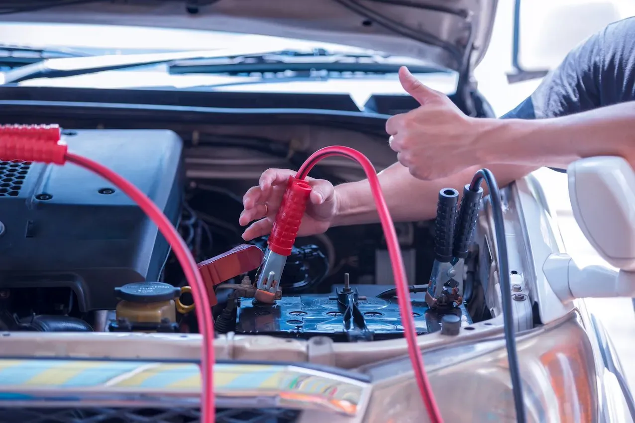 Cables de emergencia conectados a batería de auto