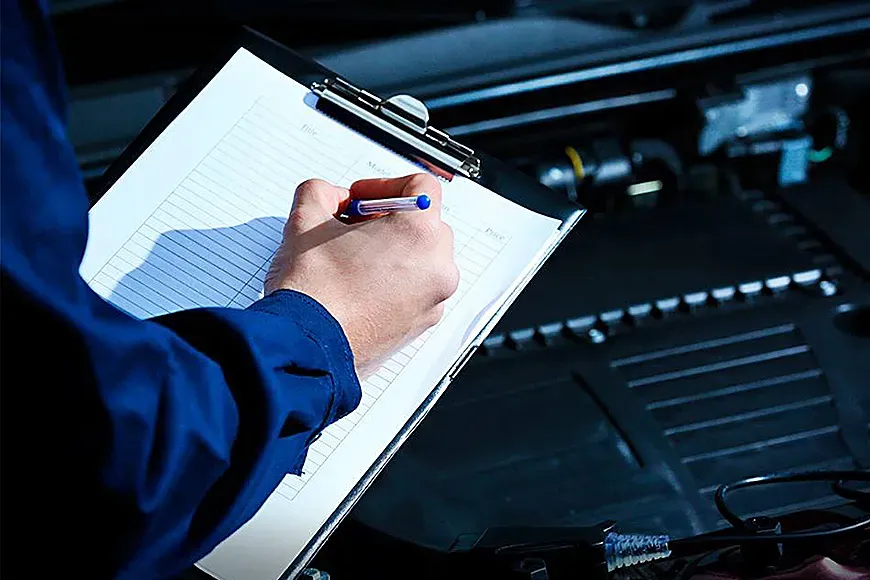 Persona realizando notas frente a un auto con el capo levantado