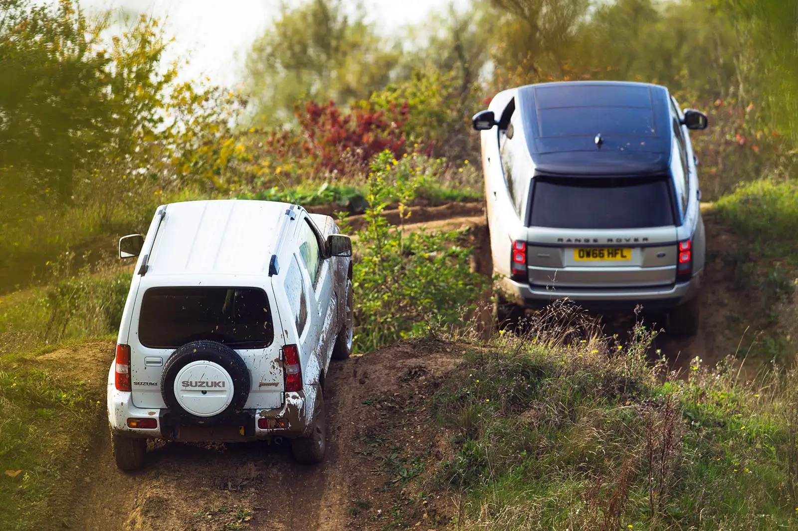 Parte Trasera Suzuki Jimny Blanco y Range Rover Gris