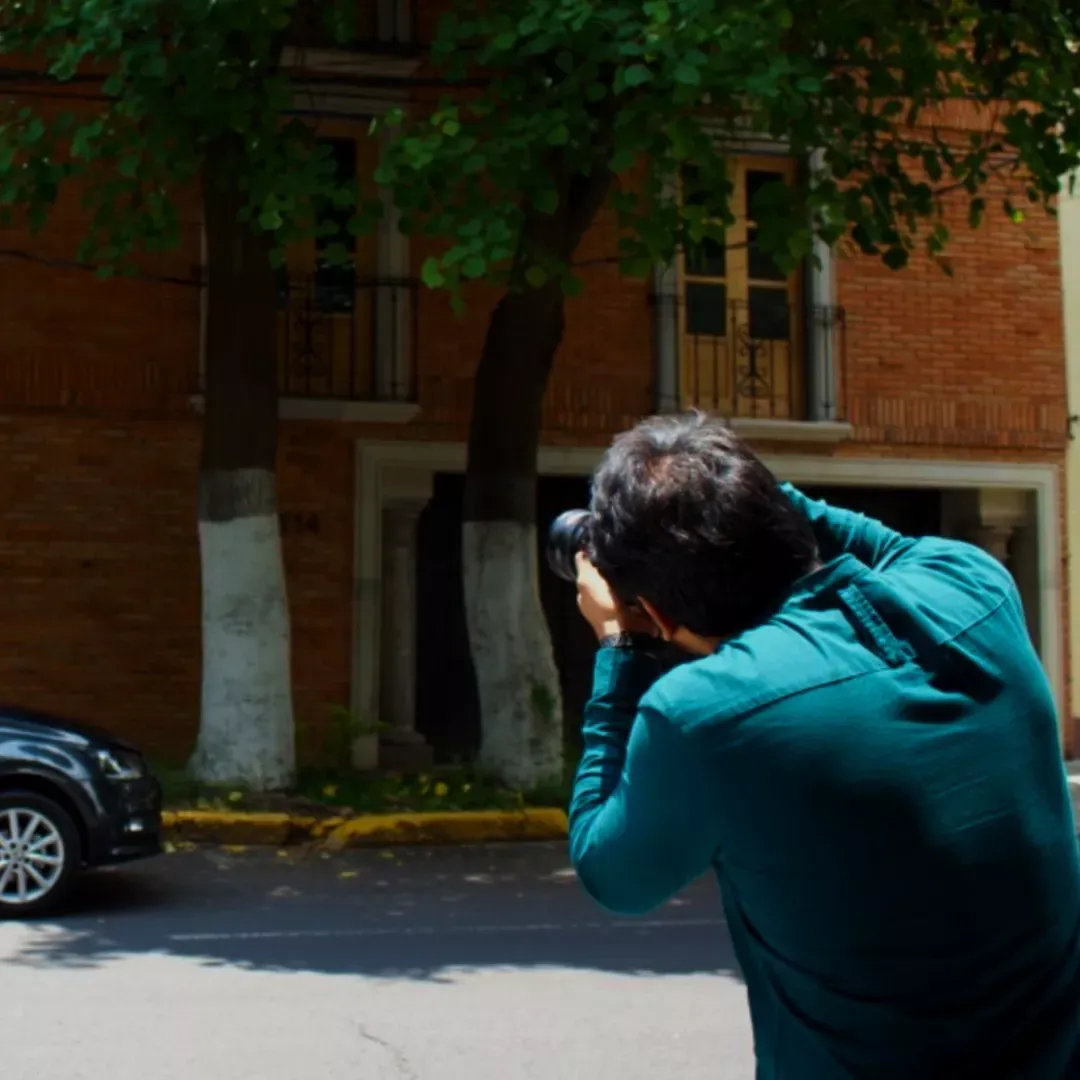 Persona tomando fotografía a un auto