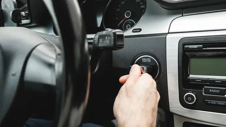 Mano arrancando auto en interior de auto