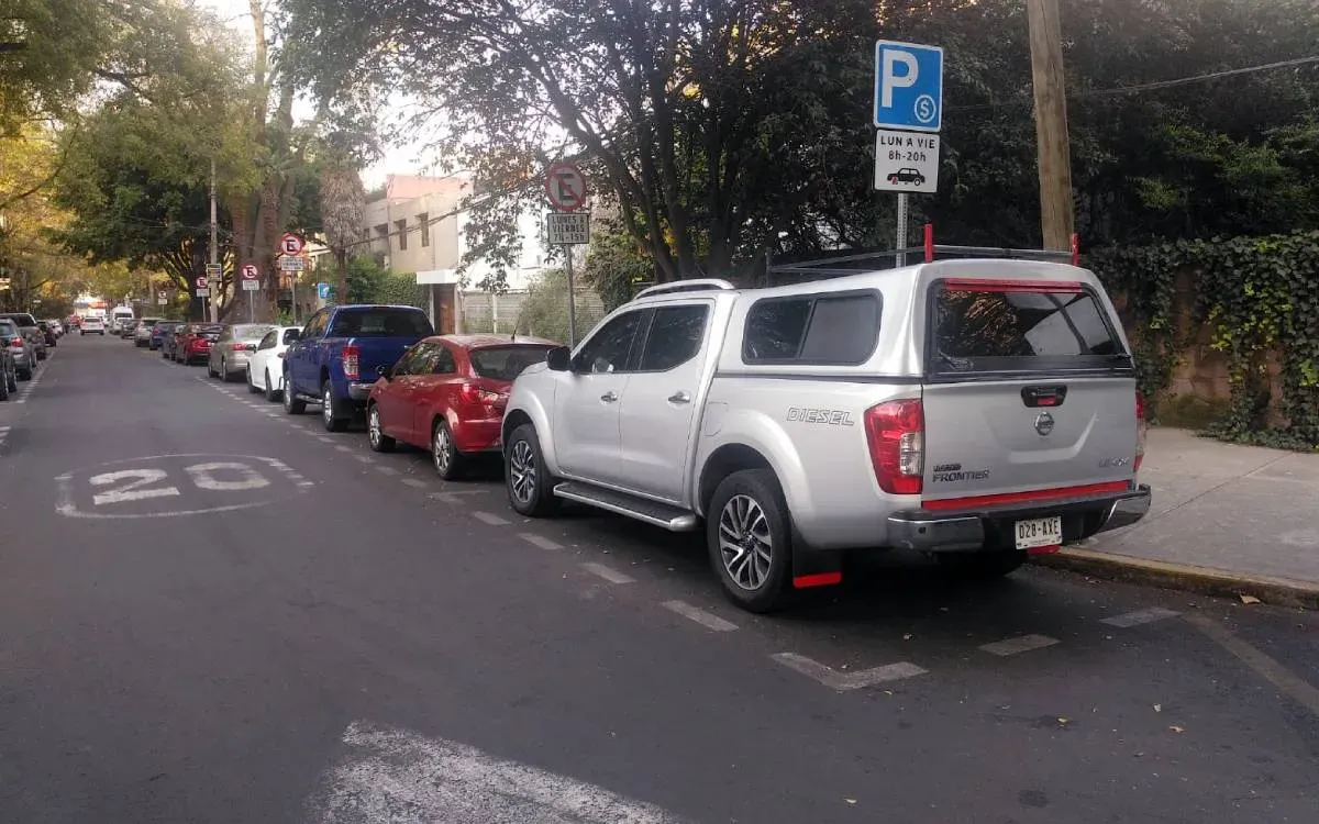 Autos estacionados en calle con parquímetro 