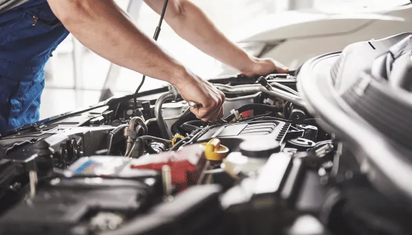 Persona revisando parte mecánica de auto