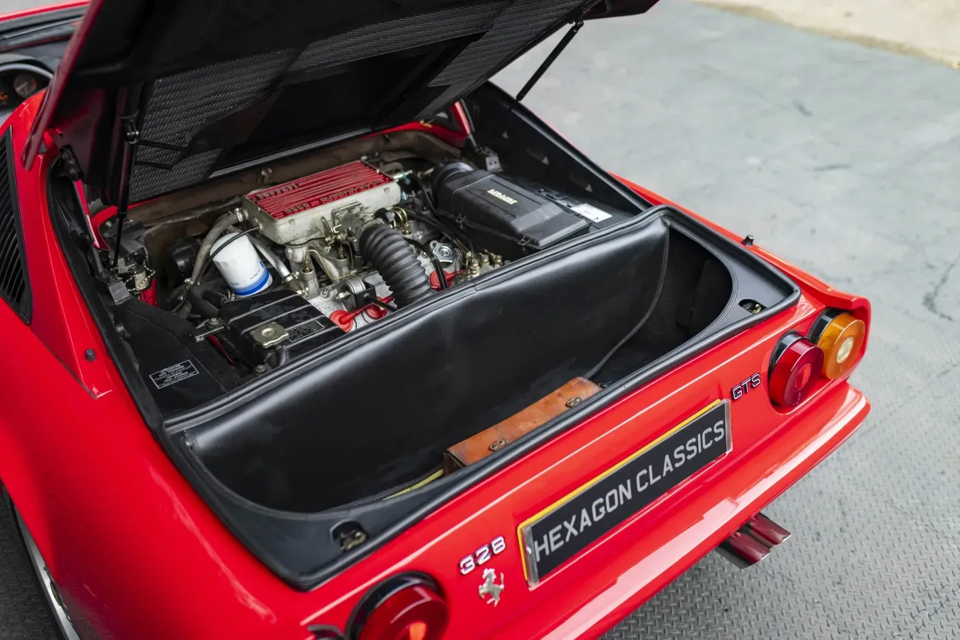 Exterior trasero del Ferrari 328 GTS con maletero abierto mostrando el motor V8