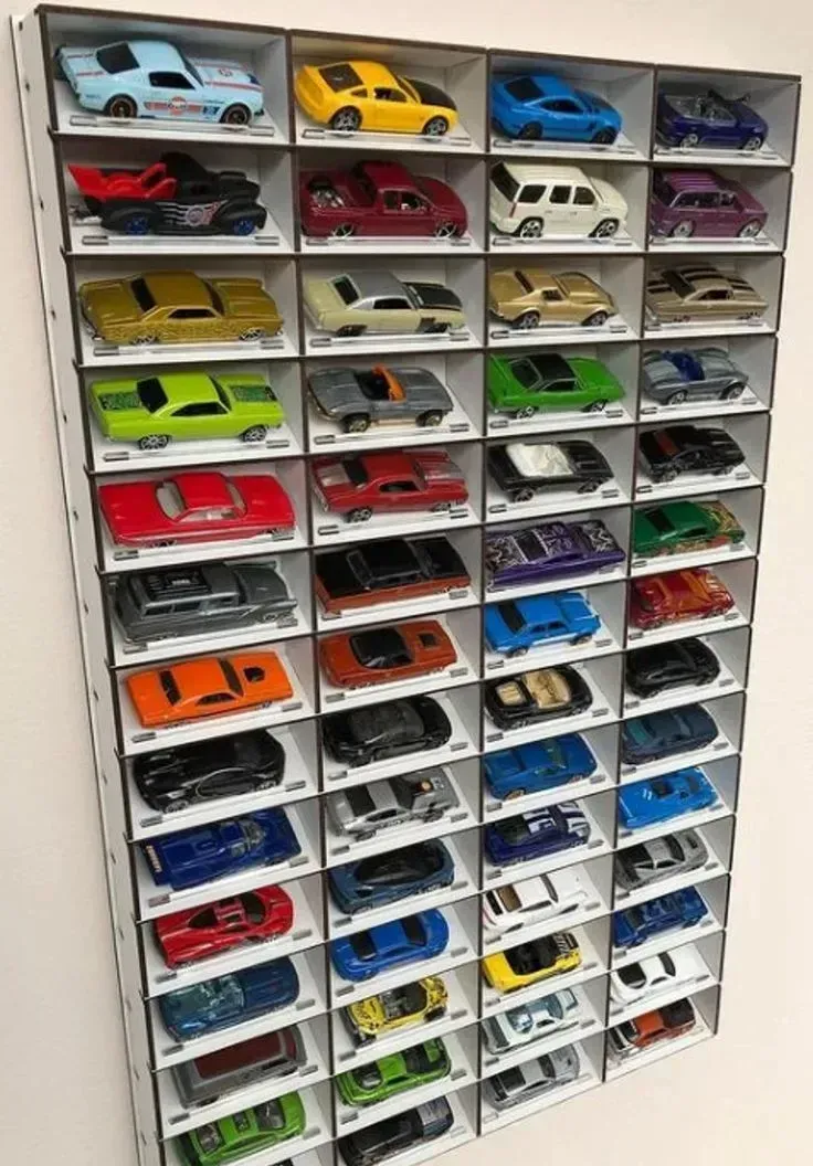 Variedad de autos de colección a escala 1:32 en una repisa 