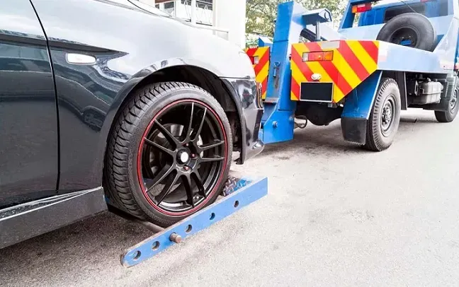 Rueda delantera de auto enganchada a grúa 