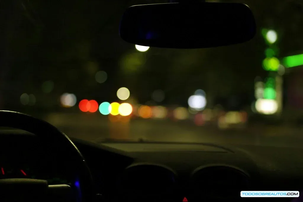 Imagen de un coche de policía deteniendo a un vehículo a alta velocidad en una carretera de noche.