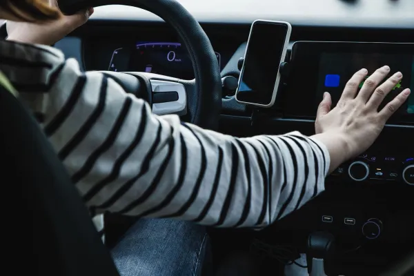 Interior de auto con integración con teléfonos inteligentes y una mano tocando la navegación gps y asistente de voz