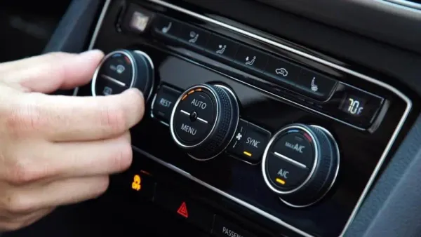 Mano girando boton de calefación de auto