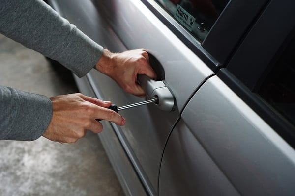 Manos forzando cerradura de auto