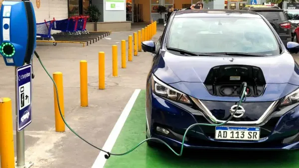 Nisan eléctrico azul cargando su batería en una estación de carga de vehículos eléctricos