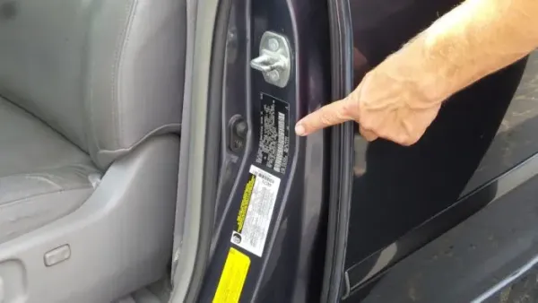 Mano señalando VIN en un auto