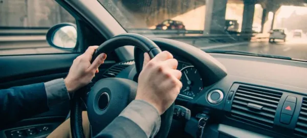 Manos en el volante de un auto