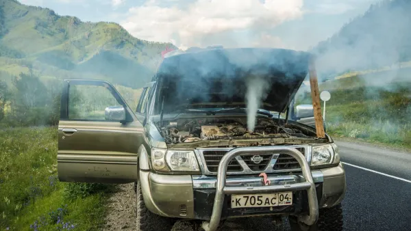 Camioneta con capo levantado y motor sobrecalentado emitiendo humo