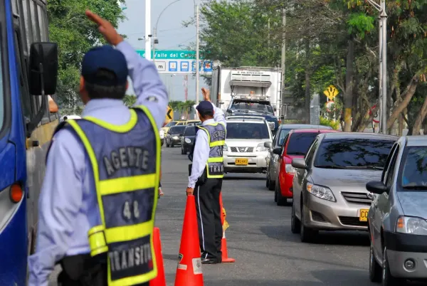 Agentes de transito colocados en control de transito en carretera y variedad de autos circulando 