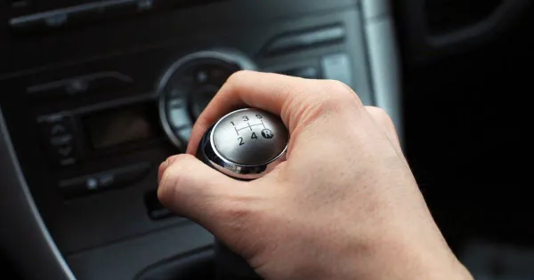 Mano sobre palanca de cambios en auto