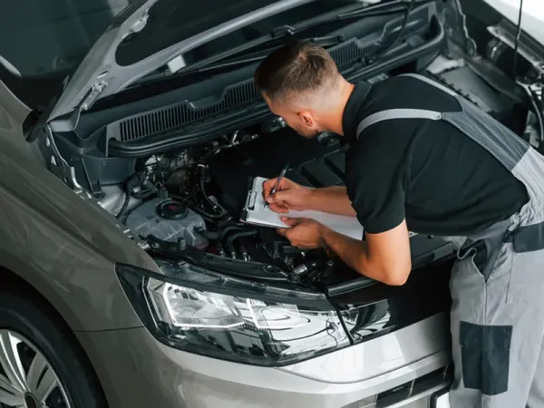 Persona realizando revisión mecánica de auto 