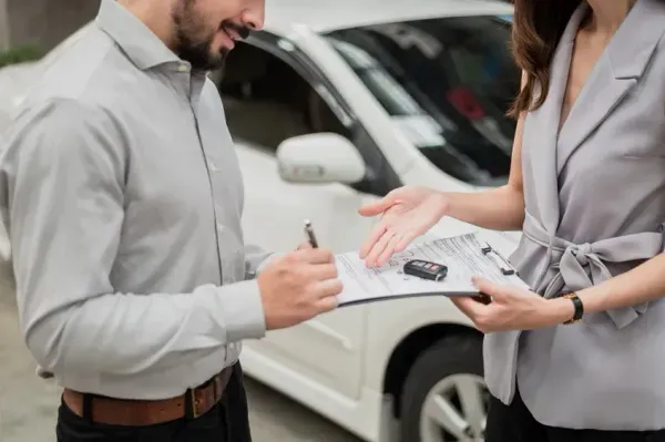 Persona entregando auto con llaves a otro