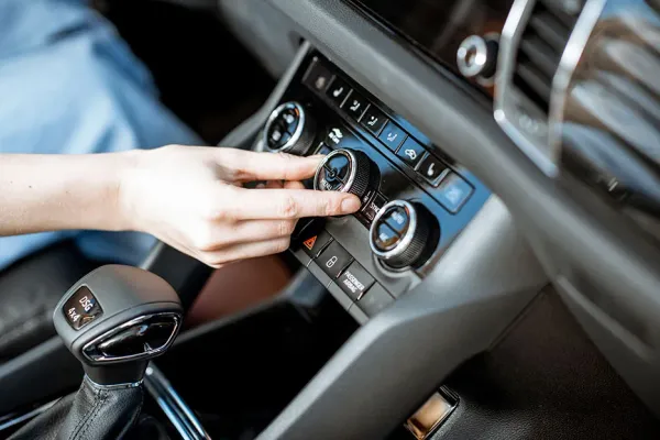 Girando botón de aire acondicionado en auto