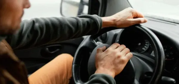 Persona con manos en el volante de auto 