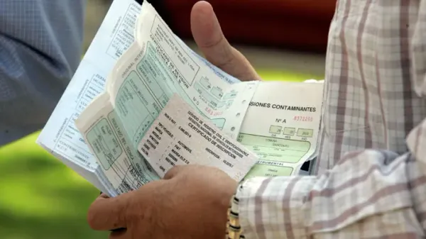 Persona con documentos de auto en la mano