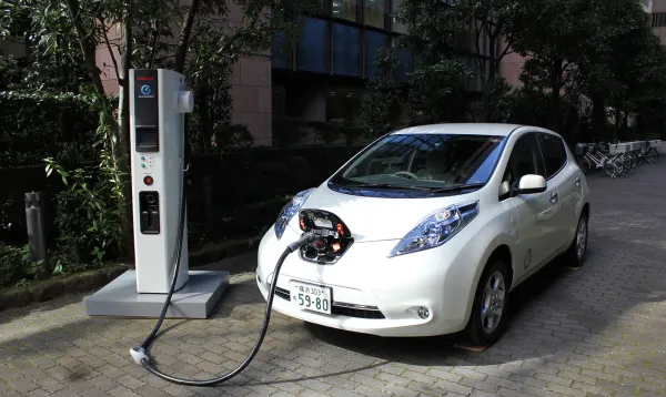 Auto eléctrico blanco recargando batería 