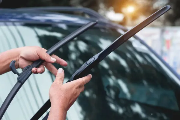 Manos subiendo limpiaparabrisas en auto 