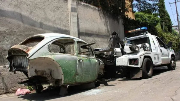 Grúa llevándose un auto en mal estado 