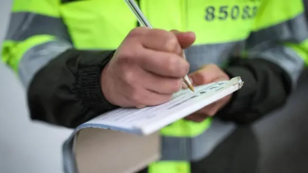 Persona con uniforme de transito tomando notas 