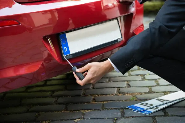 Persona desarmando porta placas de auto