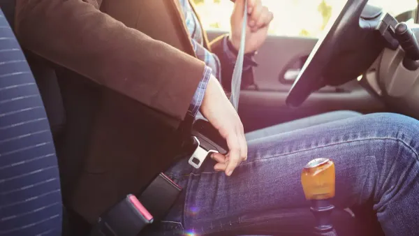 Persona colocándose cinturón de seguridad sentado en interior de auto